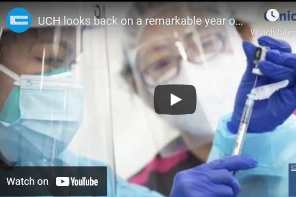 Screen shot from video showing two medical professionals preparing a dose of a COVID-19 vaccine.